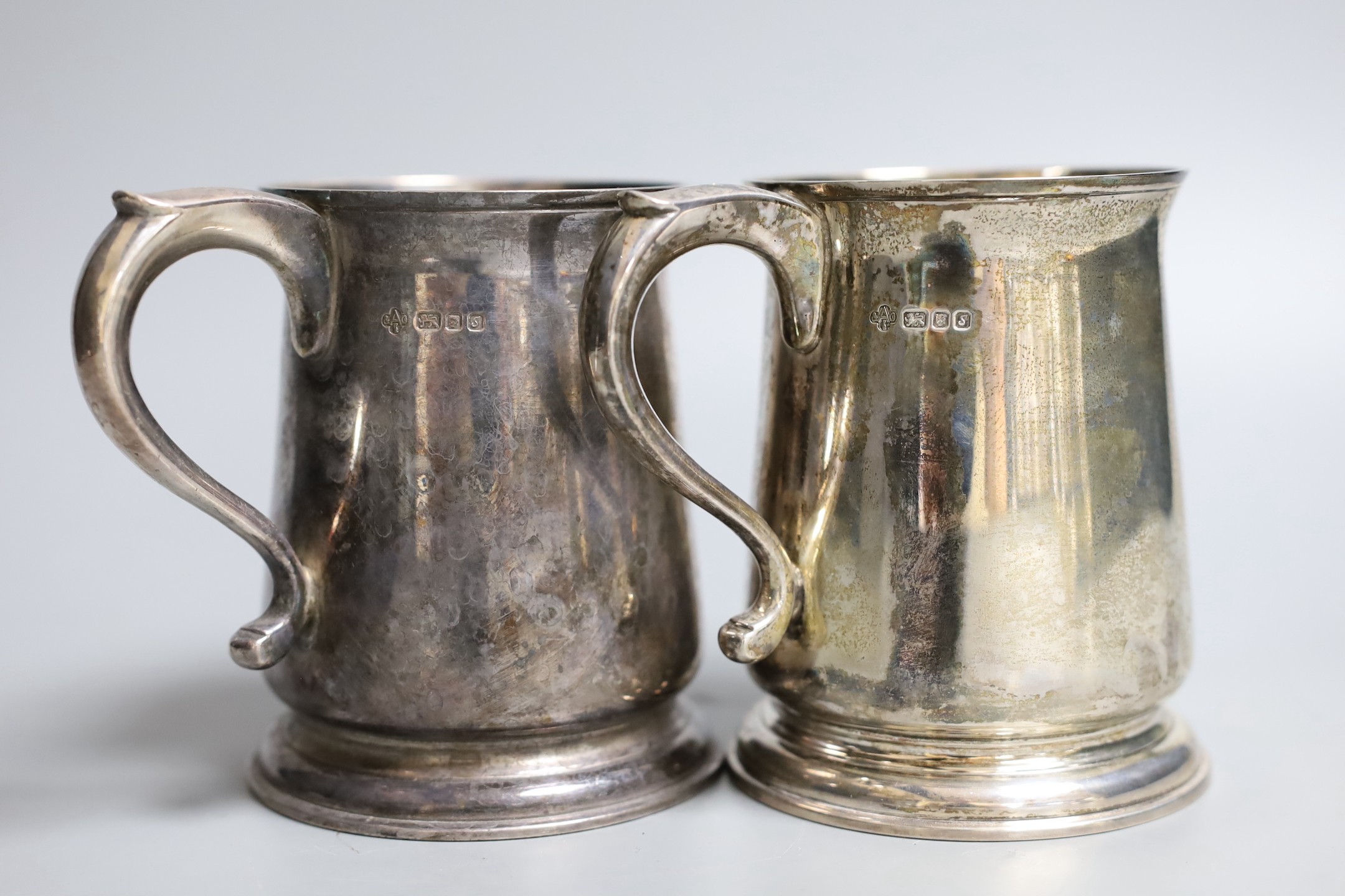A pair 1970's silver mugs with S-scroll handles, by Asprey & Co Ltd, London, 1973, height 10.8cm, 18.5oz, both with engraved monograms